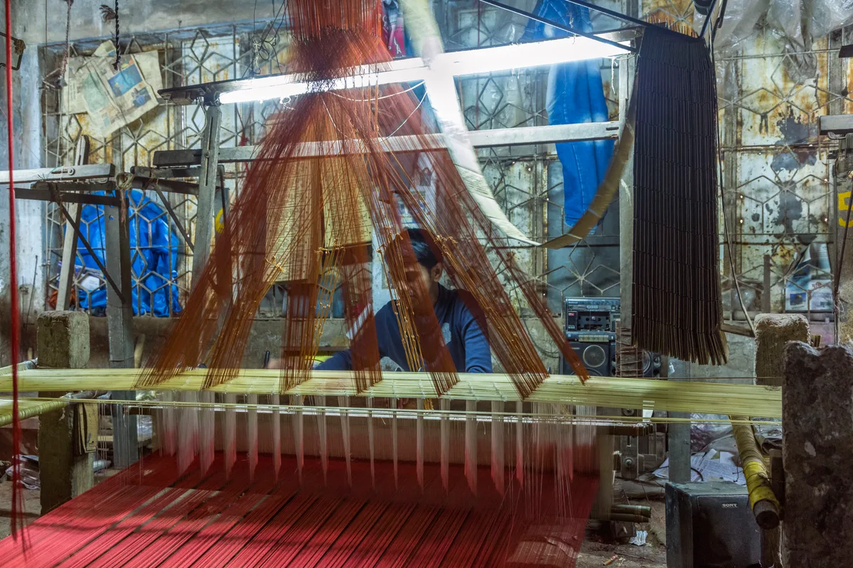 Banarasi silk weaving — craftsperson at a traditional handloom creating silk fabric